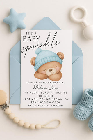Baby sprinkle invitation with teddy bear graphic and baby items on a light background